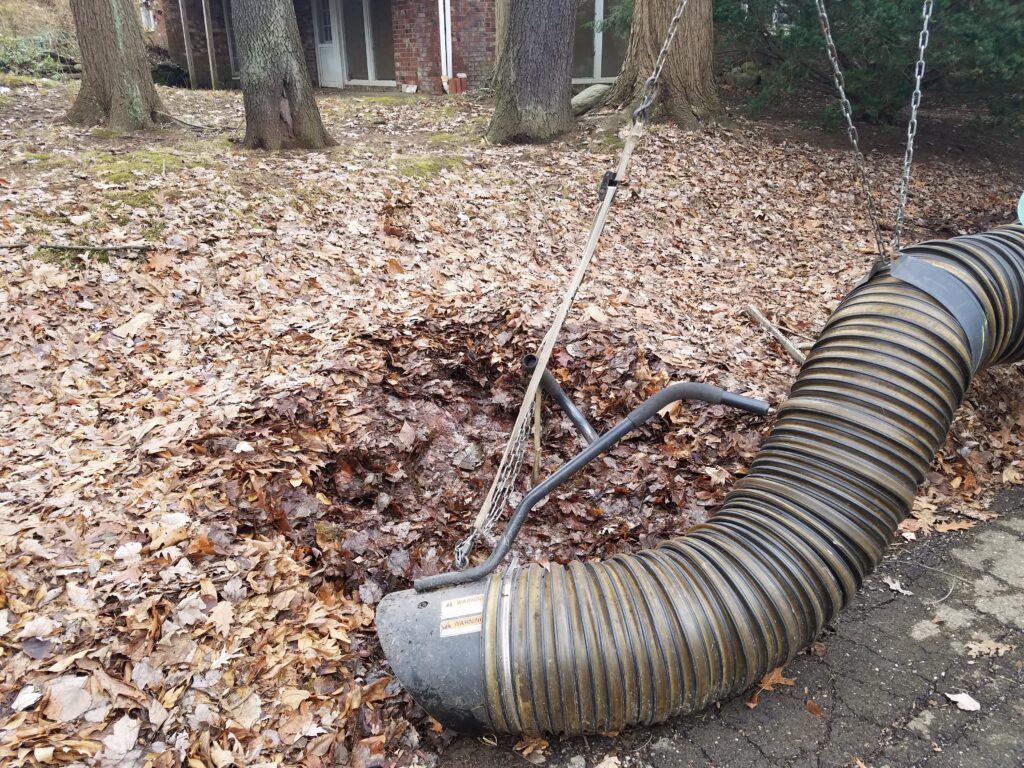 B-Sharp leaf vacuum hose clearing fallen leaves from a lawn during a fall cleanup near Clinton, Ohio